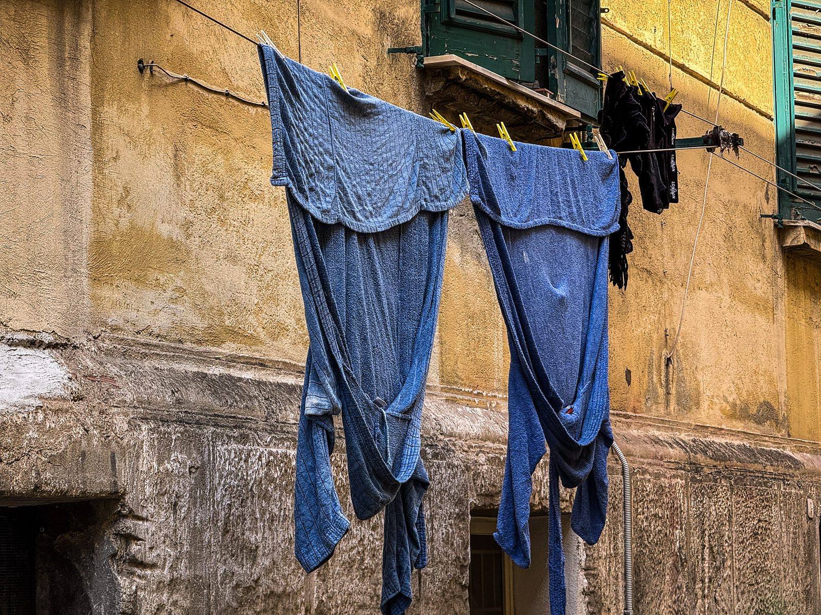 Laundry drying above a sunlit alley in Nice, France, photographed by Cole Sjoholm